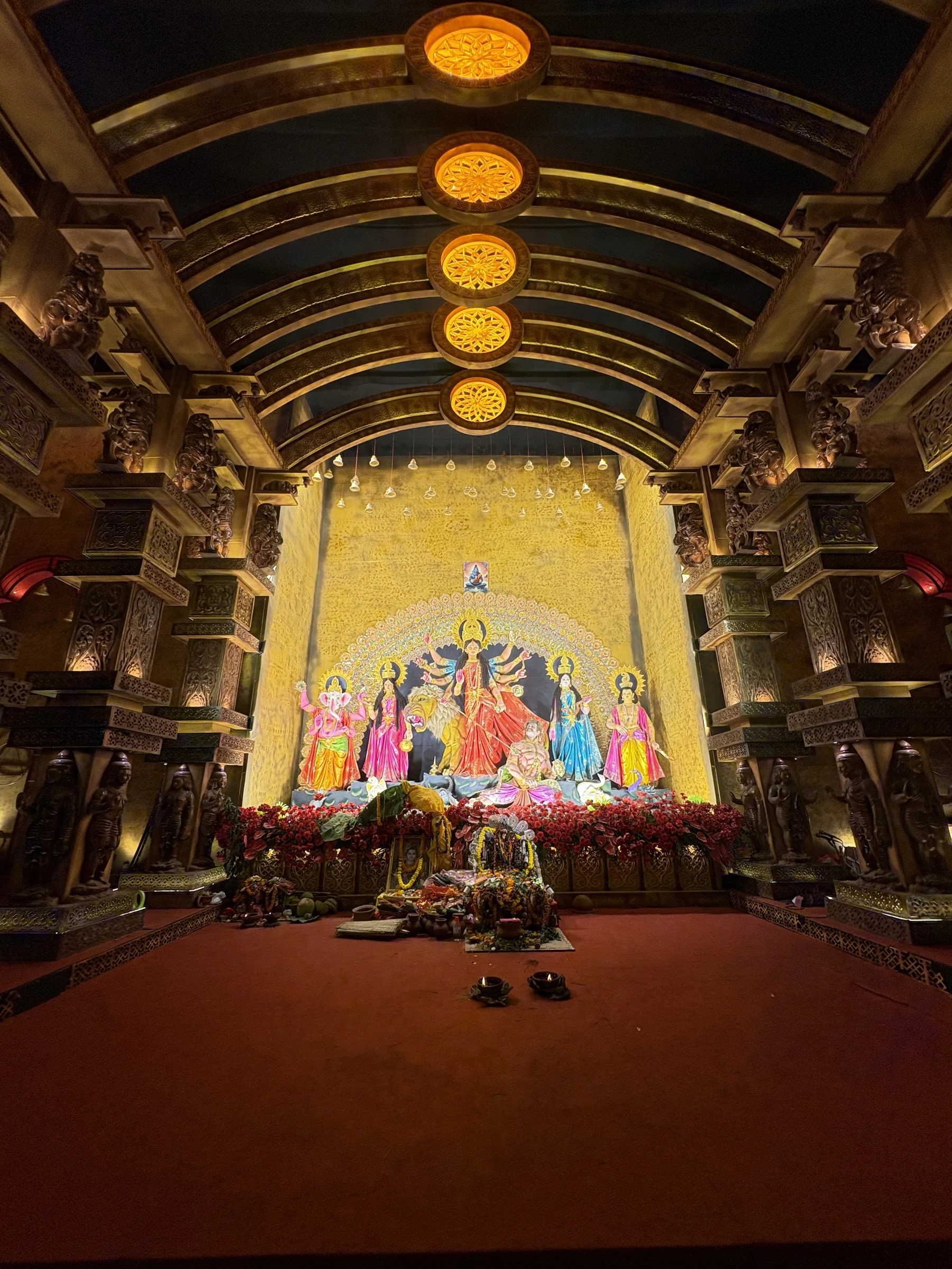 Durga idol in a warmly lit shrine framed by sculpted pillars