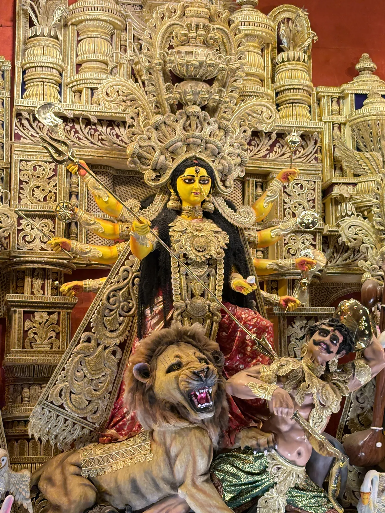 An ornate Durga idol surrounded by traditional craftsmanship
